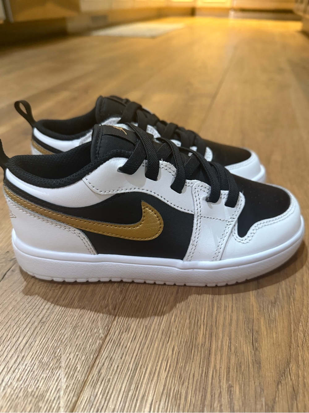 Nike Kids Low-Top Sneakers in Black, White & Gold Swoosh